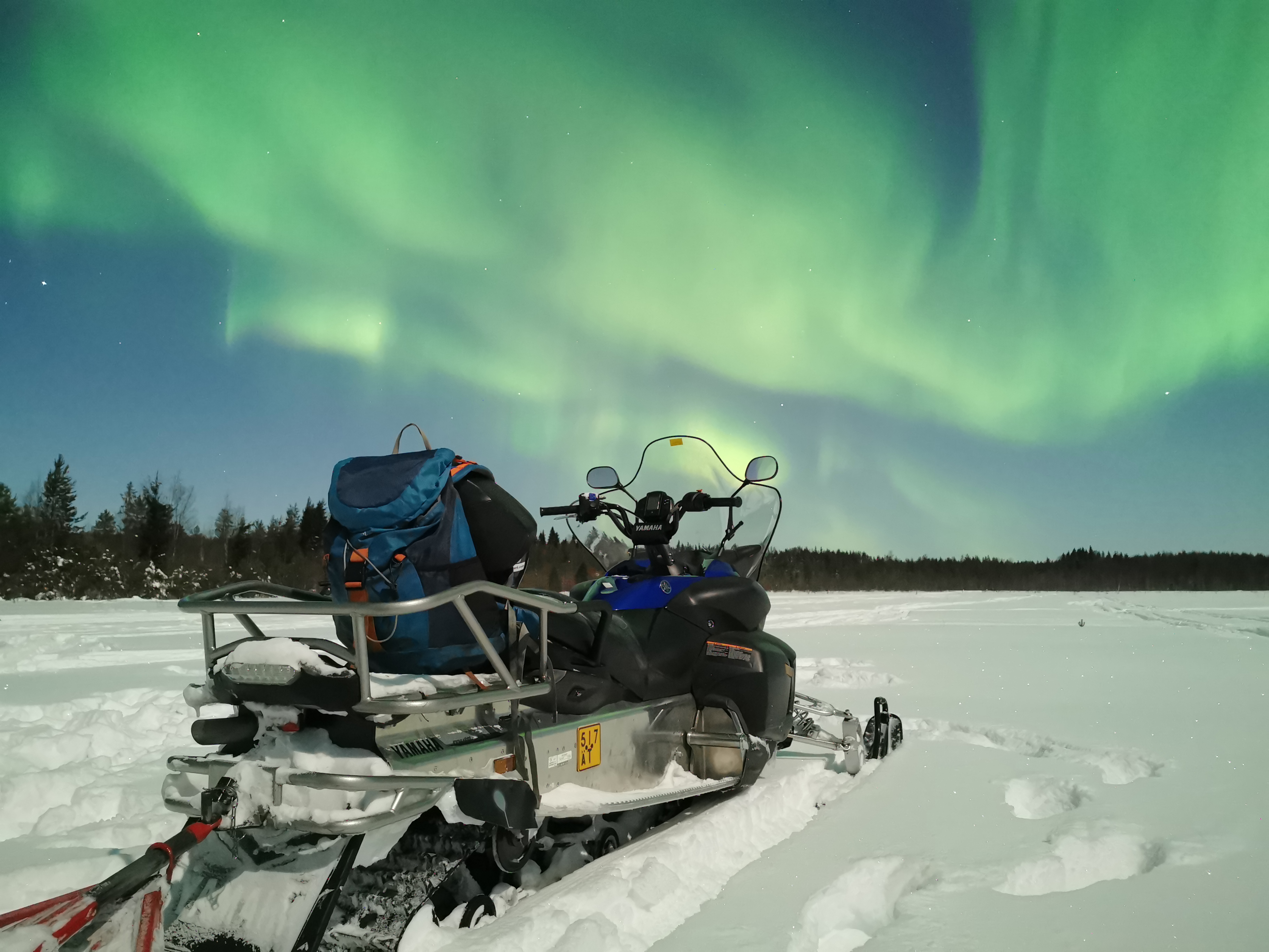 Northern lights by snowmobile