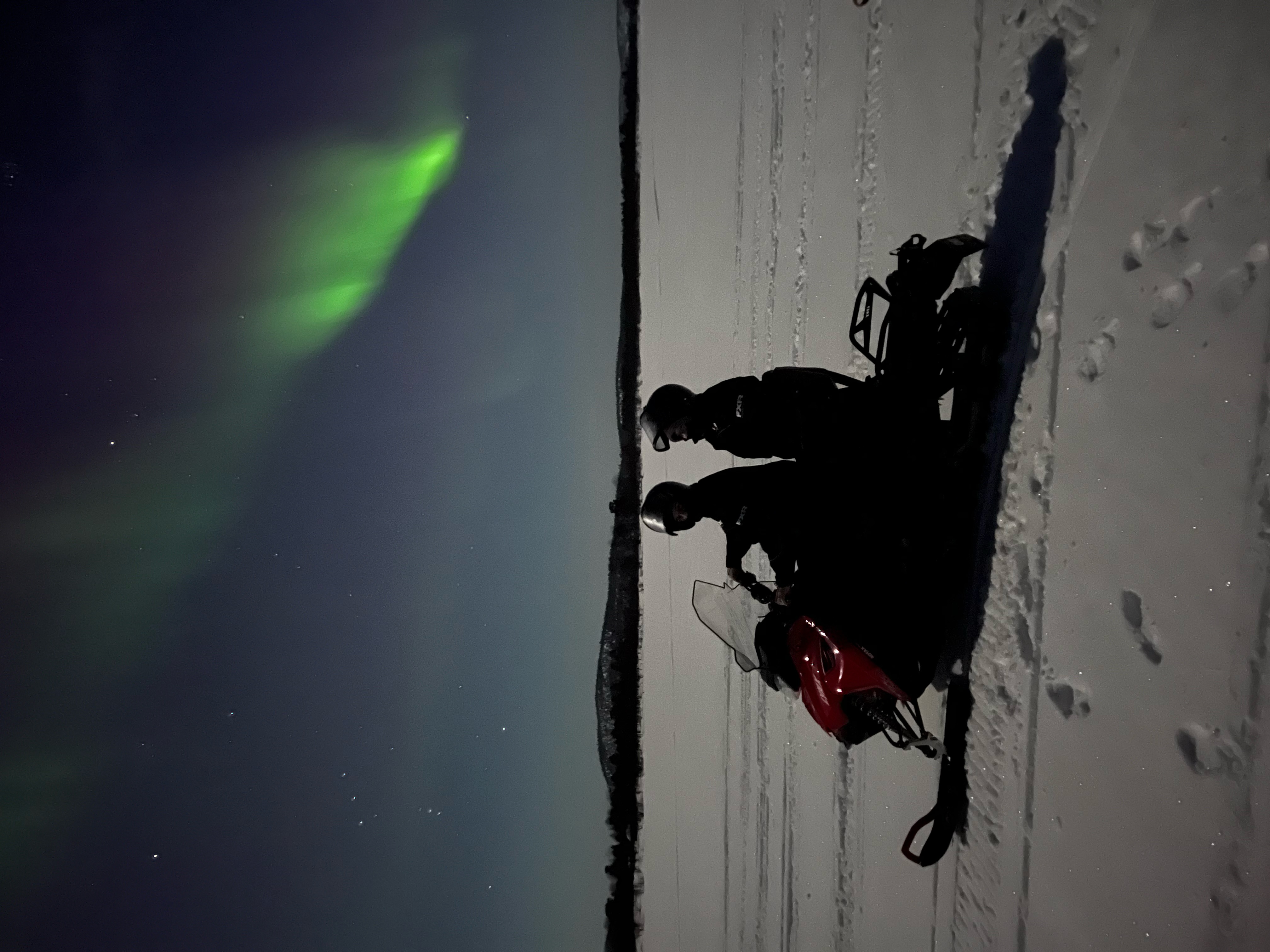 THE AURORA BOREALIS HUNTING BY SNOWMOBILE